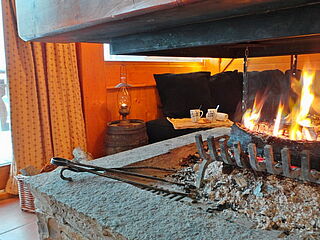 Die Skireise nach Trois Vallées in Frankreich. Hausgalerie im Ferienclub Tros Vallées. Kamin