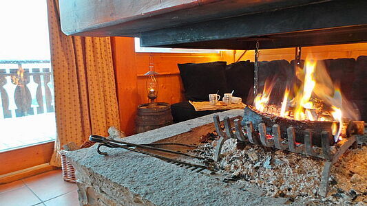 Die Skireise nach Trois Vallées in Frankreich. Hausgalerie im Ferienclub Tros Vallées. Kamin