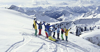 Snowboardergruppe im Tiefschnee auf einer Snowboardreise in Österreich.