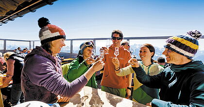 Skigruppe, die auf einer Skihütte in Bad Mitterdorf - Tauplitz ihren Skiurlaub mit guten Schnaps feiern.