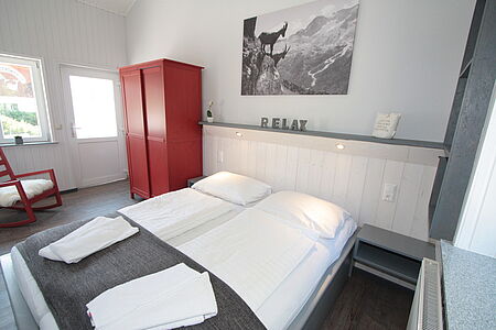 Bett. Hausgalerie von der Sommerreise der Ferienanlage Forellenhof in Kärnten in Österreich am Faaker See.