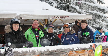 Eine Familie, die ihren Skitag auf der Hütte in Gasurn in Silvretta Montafon ausklingen lässt