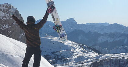 Ein Snowboarder im Nassfeld, der in seinem Skiurlaub die schöne Aussicht genießt.