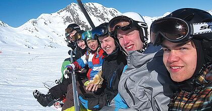 Snowboarder im Sessellift in Frankreich.